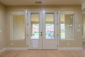 Doorway with french doors and wood finished floors