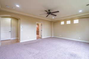Empty room featuring arched walkways, recessed lighting, light colored carpet, and ceiling fan