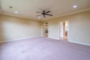 Empty room with arched walkways, light carpet, recessed lighting, and a ceiling fan