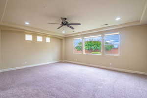 Spare room with light carpet, a raised ceiling, ceiling fan, and recessed lighting