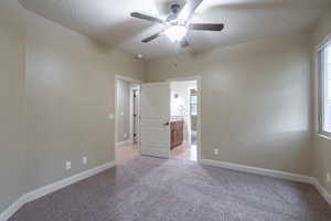 Empty room with light colored carpet and a ceiling fan