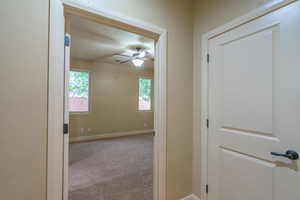 Corridor featuring carpet flooring and baseboards