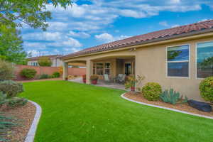 Rear view of house featuring stucco siding, a fenced backyard, a patio area, and a tile roof