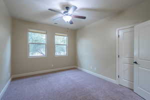 Empty room with carpet and a ceiling fan