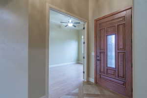 Foyer with a ceiling fan and light wood finished floors