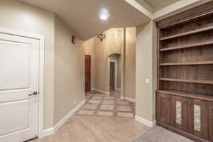 Hallway featuring light wood-style floors and arched walkways