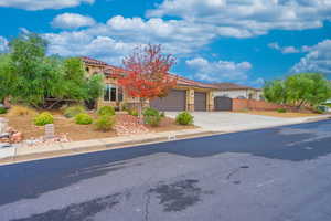 Mediterranean / spanish home featuring stucco siding, driveway, a tile roof, and an attached garage