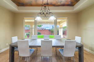 Dining space featuring a raised ceiling and hardwood / wood-style flooring