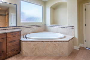 Bathroom with a bath and light wood finished floors