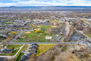 Aerial overview of property's location featuring a mountain backdrop, nearby suburban area, and property parcel outlined