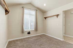 Bonus room, den, or office with vaulted ceiling and light colored carpet