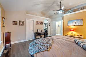 Bedroom with lofted ceiling, dark wood-style flooring, ceiling fan, and a spacious closet