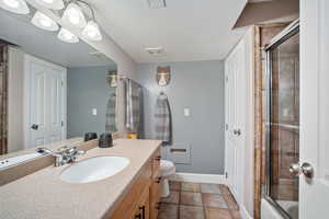 Full bath with vanity and a textured ceiling