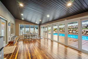 Sunroom / solarium with lofted ceiling, hardwood / wood-style floors, recessed lighting, wood ceiling, and french doors