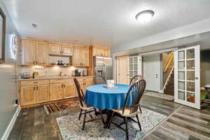 Dining area featuring stairs, dark wood-type flooring, and a textured ceiling