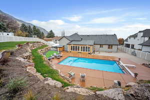 View of swimming pool featuring a fenced backyard, a patio area, a diving board, and a mountain view
