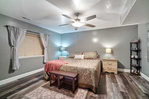Bedroom with dark wood-type flooring, a ceiling fan, and a textured ceiling