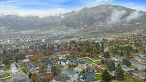 Aerial view of property and surrounding area with a mountain backdrop and nearby suburban area