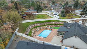 Drone / aerial view of a pool and a tree filled landscape