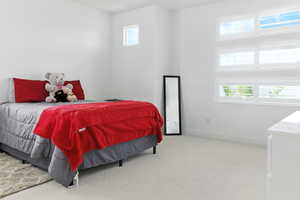 Bedroom with multiple windows and light colored carpet
