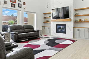 Living room featuring a premium fireplace, light wood finished floors, and built in features