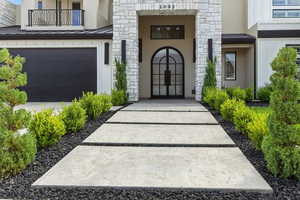 Entrance to property with stucco siding, stone siding, a standing seam roof, and a metal roof