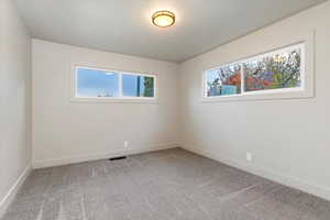 Bedroom with baseboards and light colored carpet