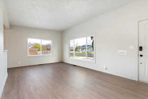Family room with light wood finished floors and a textured ceiling