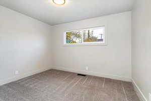 Empty room with light carpet and baseboards