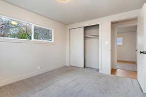 Unfurnished bedroom featuring a closet and light carpet