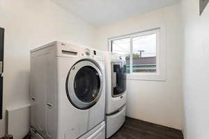 Washroom featuring washing machine and dryer and dark wood-type flooring