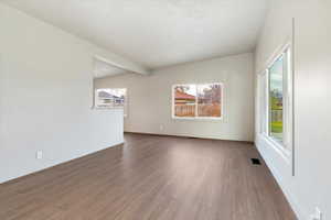 Family room featuring wood finished floors, plenty of natural light, and beamed ceiling