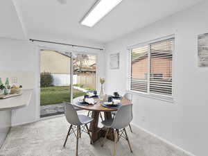 Dining space with light colored carpet and baseboards