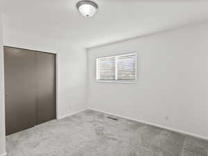 Unfurnished bedroom with a closet and carpet