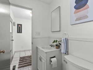 Half bathroom featuring vanity, electric panel, and light tile patterned floors