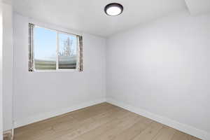 Empty room with light wood-style flooring and baseboards