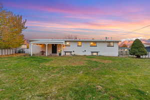 Back of property at dusk with a patio and brick siding