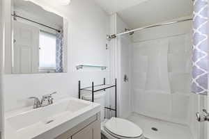 Full bath with a shower stall and vanity