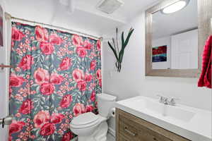 Bathroom featuring a shower with shower curtain and vanity