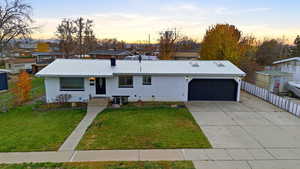 View of front of home with a metal roof, concrete driveway, brick siding, and a garage
