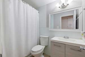Bathroom featuring a shower with shower curtain, vanity, and a chandelier