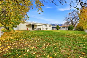 Back of house with a fenced backyard, a patio, and a mountain view