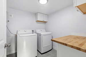 Laundry room with independent washer and dryer and cabinet space