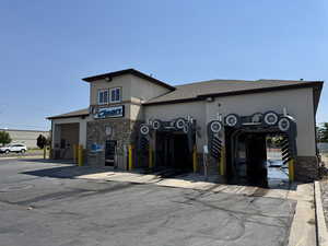 View of front of property featuring stone siding and a shingled roof