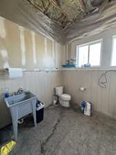 Bathroom with toilet and wood walls