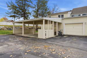View of side of property featuring driveway, a carport, and a garage