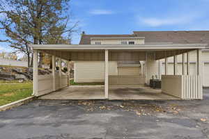 View of vehicle parking with driveway and a carport