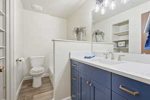 Full bath with vanity, light wood-style flooring, a closet, bathtub / shower combination, and built in features