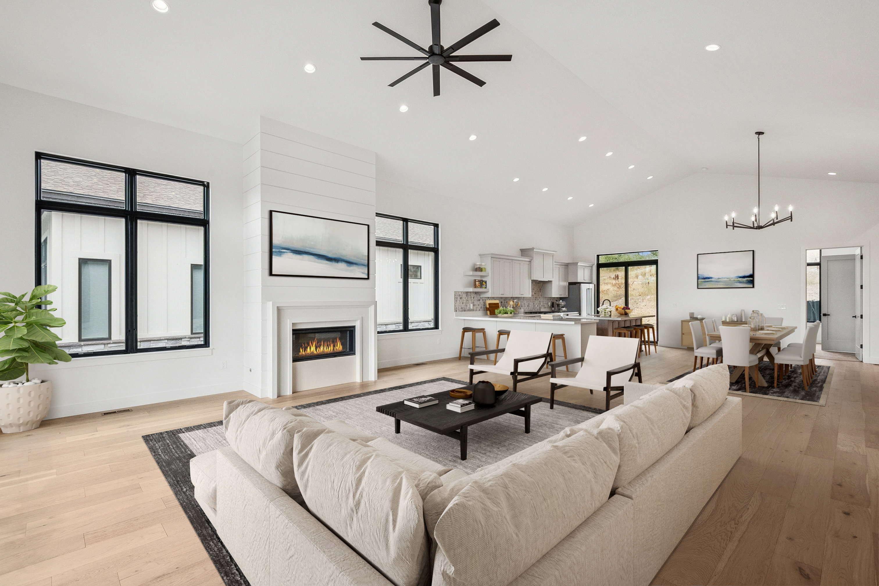 Upper level great room featuring a glass covered gas fireplace, light wood finished floors, high vaulted ceiling, recessed lighting, and ceiling fan (virtual staging)