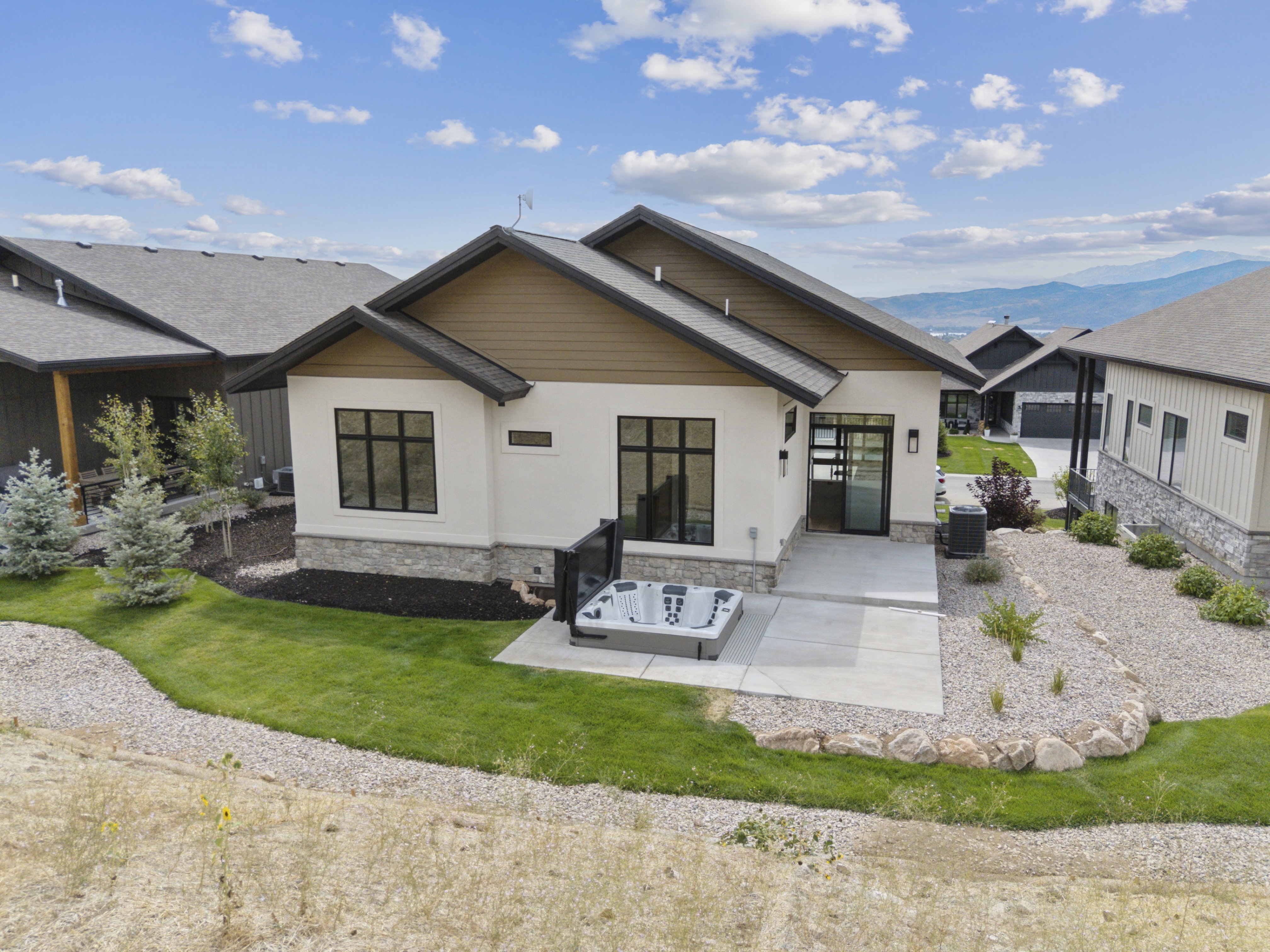 Back of property featuring a hot tub, gas line for BBQ and mountain view.